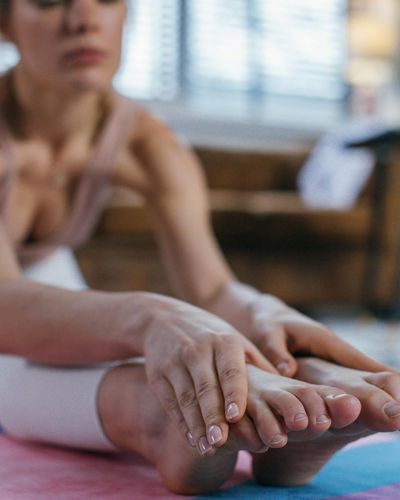 Close-up on hands and feet in a specific yoga pose, showing stability.